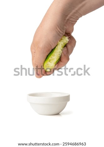 Squeezed lime isolated, hand squeezing out half green lemon, squeezed lime juice on white background, burnout symbol, making a Cuba Libre cocktail