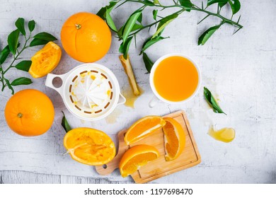 Squeezed orange juice and fresh oranges fruits on white wooden table