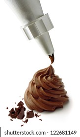 Squeezing Chocolate Cream With Piping Or Icing Bag On Cupcake With Chocolate Parts Isolated On White Background.