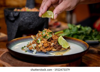 Squeezing lime in Fresh gourmet taco on plate - Powered by Shutterstock