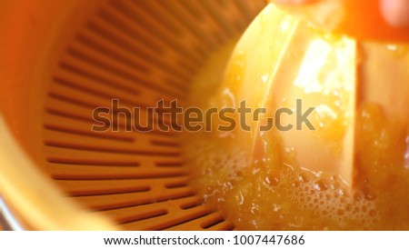 Squeezing orange juice by hands on juicemachine