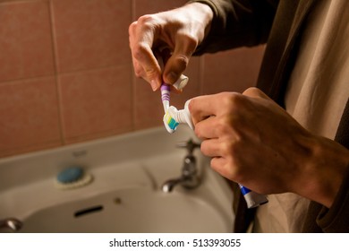 squeezing toothpaste onto a toothbrush