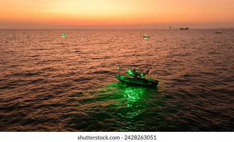 Squid fishing boat Turn on the squid lure light after sunset. Fishing boat go to ocean for catching fish all a long night - at Thailand. Top view of Fishing Boat	

 - Powered by Shutterstock