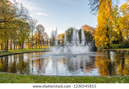 Squirting fountains in the pond of the Valkenberg park in the Dutch city of Breda in the fall season.