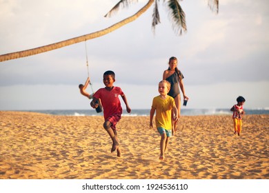 Sri Lanka, Pinkanda, 2020. Multiethnic Children And Women On The Sandy Beach Of The Ocean Play During The Day