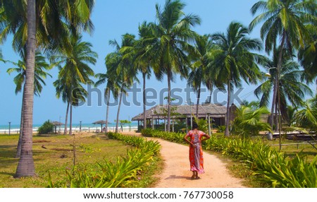 Sri lanka woman in beautiful sari walking toward beautiful Nilaveli beach 