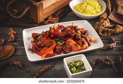 Sri Lankan devilled chicken cuisine dish on wooden background - Shutterstock ID 2231043475
