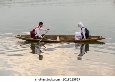Srinagar, India - july 02, 2015 : Lifestyle in Dal lake, local people use Shikara, a small boat for transportation in lake of Srinagar, Jammu and Kashmir state, India. Indian guy and girl on a boat