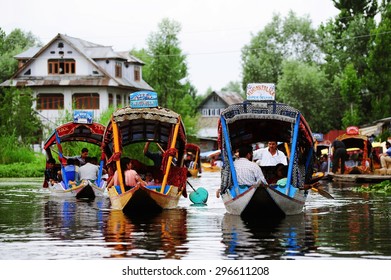 SRINAGAR, INDIA - JUNE 23, 2012 : Tourist are relaxing when sitting on boat at Dal Lake, surrounded by mountains in Kashmir. Srinagar, India