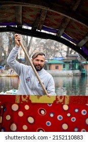 SRINAGAR, INDIA - Mar 01, 2022: A portrait of a Kashmiri Shikara boat sailor Indian man on Dal Lake  The hands might be blurred due to motion 