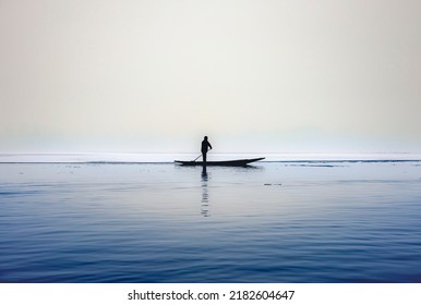 Srinagar, Jammu and Kashmir - 10th Jan 2021 : Person rowing a boat at partial frozen Dal lake, Srinagar.  