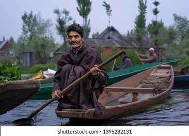 Srinagar, Jammu and Kashmir - April 16, 2019 : Kashmiri men with old wooden boat rowing to floating market on Dal Lake daily early morning is major tourist attractions in Srinagar