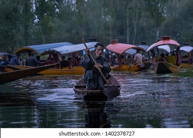 Srinagar, Jammu and Kashmir - April 16, 2019 : Kashmiri men old wooden boat rowing to floating market on Dal Lake daily early morning is major tourist attractions in Srinagar, Kashmir, India