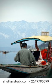 Srinagar, Jammu and Kashmir, India - March 1 2022: A portrait of a Kashmiri Shikara boat sailor Indian man on Dal Lake. The hands might be blurred due to motion.