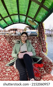 Srinagar, Jammu and Kashmir, India - March 1 2022: A selective focus of a young Indian woman enjoying Shikara boat ride on Dal Lake, Srinagar, Jammu and Kashmir, India.