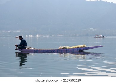Srinagar, Jammu and Kashmir, India - March 1 2022: A portrait of a Kashmiri Shikara boat sailor and Flowers vendor Indian man on Dal Lake. The hands might be blurred due to motion.