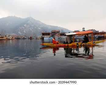 Srinagar, Kashmir, India - March 2014 : tourists in traditional Kashmiri dress posing for photos in shikaras of Dal lake, blurry shot
					