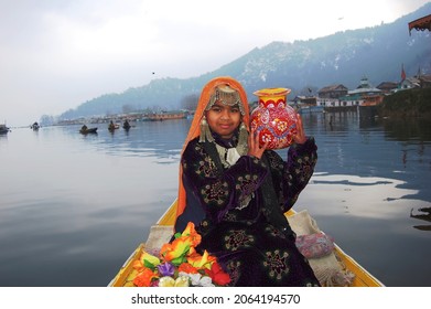 Srinagar, Kashmir, India - March 2014 : a baby girl in traditional Kashmiri attire posing for a photo in a shikara in Dal Lake, blurry shot