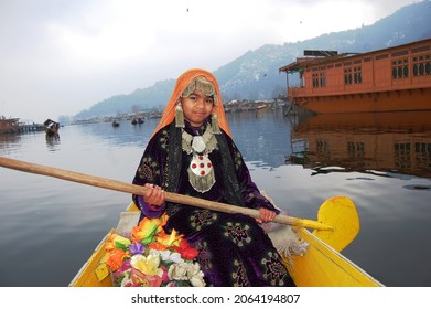 Srinagar, Kashmir, India - March 2014 : a baby girl in traditional Kashmiri attire posing for a photo in a shikara in Dal Lake, blurry shot