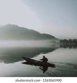 Srinagar, Kashmir / India - October 01 2018 : An Old Man Kayaking Across The River On The Gloomy Morning