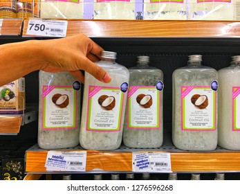 Sriracha, Chonburi THAILAND Dec 18, 2018: Man's Hand Is Holding Spa Coconut Oil  Bottle From Supermarket Shelf