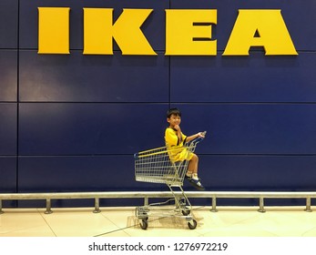 Sriracha, Chonburi THAILAND Dec 18, 2018:  Kid On Shopping Card With IKEA Logo Background. Furniture Build In For Kid Concept.