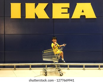 Sriracha, Chonburi THAILAND Dec 18, 2018:  Kid On Shopping Card With IKEA Logo Background. Furniture Build In For Kid Concept.