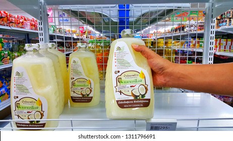 Sriracha, Chonburi THAILAND Dec 18, 2018: Man's Hand Is Holding  Virgin Coconut Oil Bottle From Supermarket Shelf