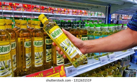 Sriracha, Chonburi THAILAND Dec 18, 2018: Man's Hand Is Holding Olive Oil Bottle From Supermarket Shelf