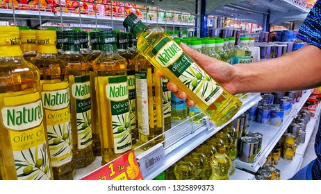 Sriracha, Chonburi THAILAND Dec 18, 2018: Man's Hand Is Holding Olive Oil Bottle From Supermarket Shelf