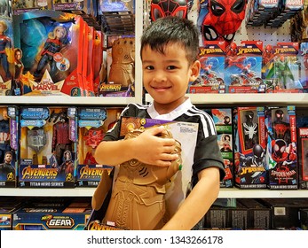 Sriracha, Chonburi THAILAND Dec 18, 2018: Kid's Hand Is Holding Thanos Glove Toy In Supermarket Toy Shop.