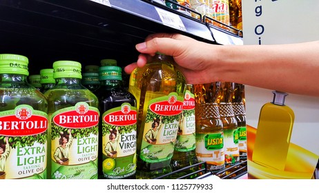 Sriracha, Chonburi THAILAND June 29, 2018: Man's Hands Are Holding Bertolli Olive Oil In Bottle On A Shelf In A Supermarket.