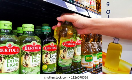 Sriracha, Chonburi THAILAND June 29, 2018: Man's Hands Are Holding Bertolli Olive Oil In Bottle On A Shelf In A Supermarket.