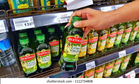 Sriracha, Chonburi THAILAND June 9, 2018: Man's Hands Are Holding Bertolli Olive Oil In Bottle On A Shelf In A Supermarket.