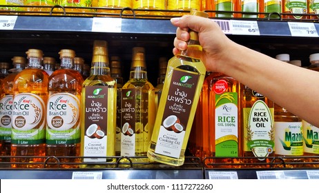 Sriracha, Chonburi THAILAND June 9, 2018: Man's Hands Are Holding Coconut Cooking Oil On A Shelf In A Supermarket.