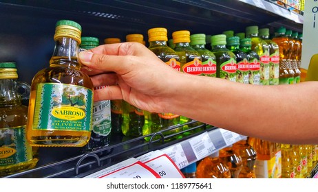 Sriracha, Chonburi THAILAND Sep  18, 2018: Women's Hand Are Holding  Olive Oil Bottle From Supermarket Shelf