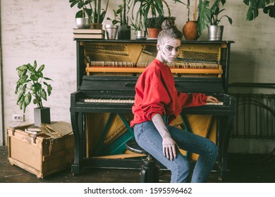 Srrange young girl and drawings her face sitting chair in interior room and piano background 