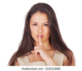 Ssh, lets keep it between us.... A young businesswoman with her finger on her lips while isolated on white.