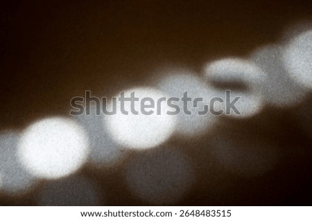 sstkBackgrounds: The sun casts its reflection through a window blind.
