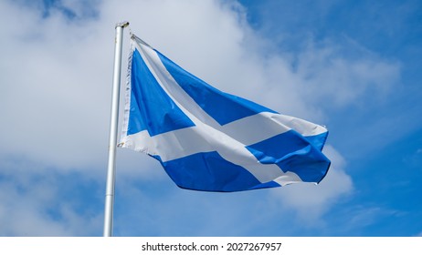 The St. Andrew Cross Or Saltire, National Flag Of Scotland, Flying In The Wind With A Blue Sky In The Background