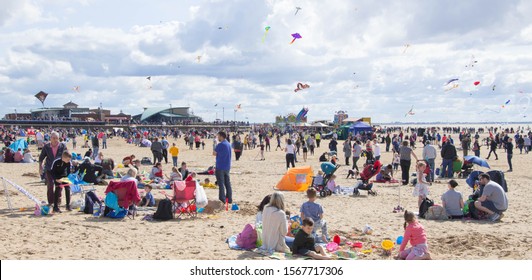 St Annes on the Sea, Lancashire/UK - September 7th 2019: Kite Festival, crowded busy beach scene with families and children on the sand enjoying the kites and bright summer sunny weather