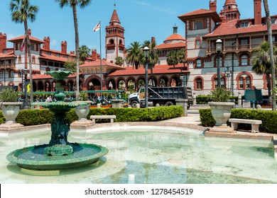 St. Augustine, USA - May 10, 2018: Flagler College With Florida Architecture, Famous Statue In Historic City, Water Fountain And Trolley Tour Guide Tram