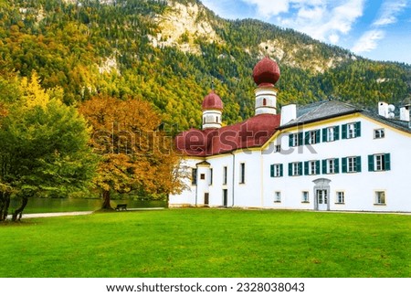 St. Bartholomew's Church with red onion domes in Berchtesgaden near Konigsee Lake, southern Bavaria, Germany. Autumn scene with colorful foliage, alpine lake and Watzmann mountain
