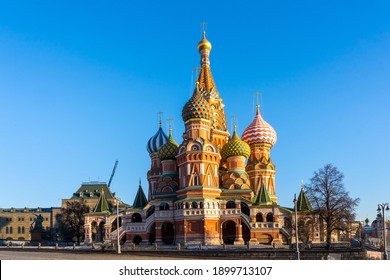 St. Basil's Cathedral (Pokrovsky Cathedral) lit by the sun on the right against the background of a bright blue sky. Moscow, Russia. December 9, 2020