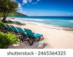 St. Croix, US Virgin Islands - September 8, 2016: Two rows of teal fabric lounge chairs line white sand beach with a view of beautiful Caribbean Sea.