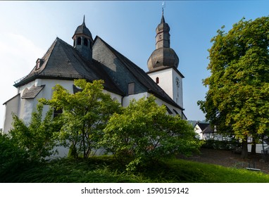 St. Georg Church with slate roofs and Clock Tower in the old town of Arnsberg Sauerland Germany on a sunny day with blue sky