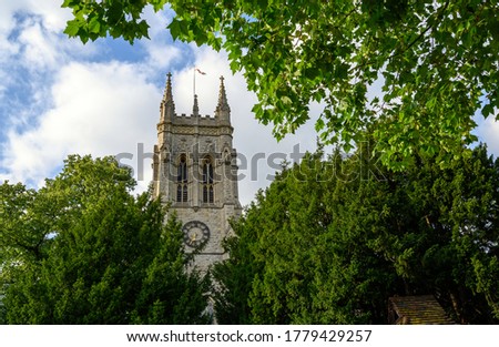 St George's Church in Beckenham with a square tower framed by trees. A Church of England parish church in Beckenham (Greater London), Kent, UK. 