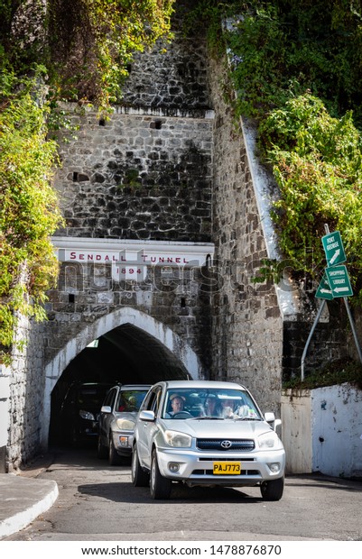 ST. GEORGE\'S, GRENADA - FEBRUARY 2,\
2019:  Photo of cars emerging from the Sendall Tunnel, a narrow\
340-ft passageway built in 1894 for horse\
carriages.