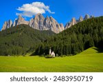 St Johann Church with landscape view of dolomites mountain peaks and blue sky, Santa Magdalena alpine village, Italy