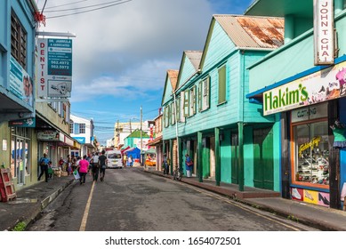 St John's, Antigua and Barbuda - December 18, 2018: Street view of St John's at rainy day with pedestrians and shops in St. John's, Antigua, West Indies, Caribbean.